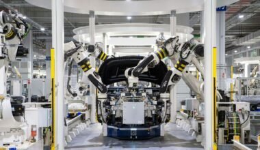 High-tech robots assembling a car in a modern factory setting, showcasing automation.